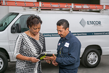 HVAC technician reviewing a project with customer on laptop